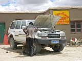 Tibet Kailash 05 To Tirthapuri 06 Moincer Landcruiser Being Fixed As we went over a particularly big bump, Sadim stopped the Landcruiser and looked underneath. He walked up a hill and found some wire, and made some emergency fixes. When we got to Moincer (4420m), the local mechanic took about four hours to make the repairs.